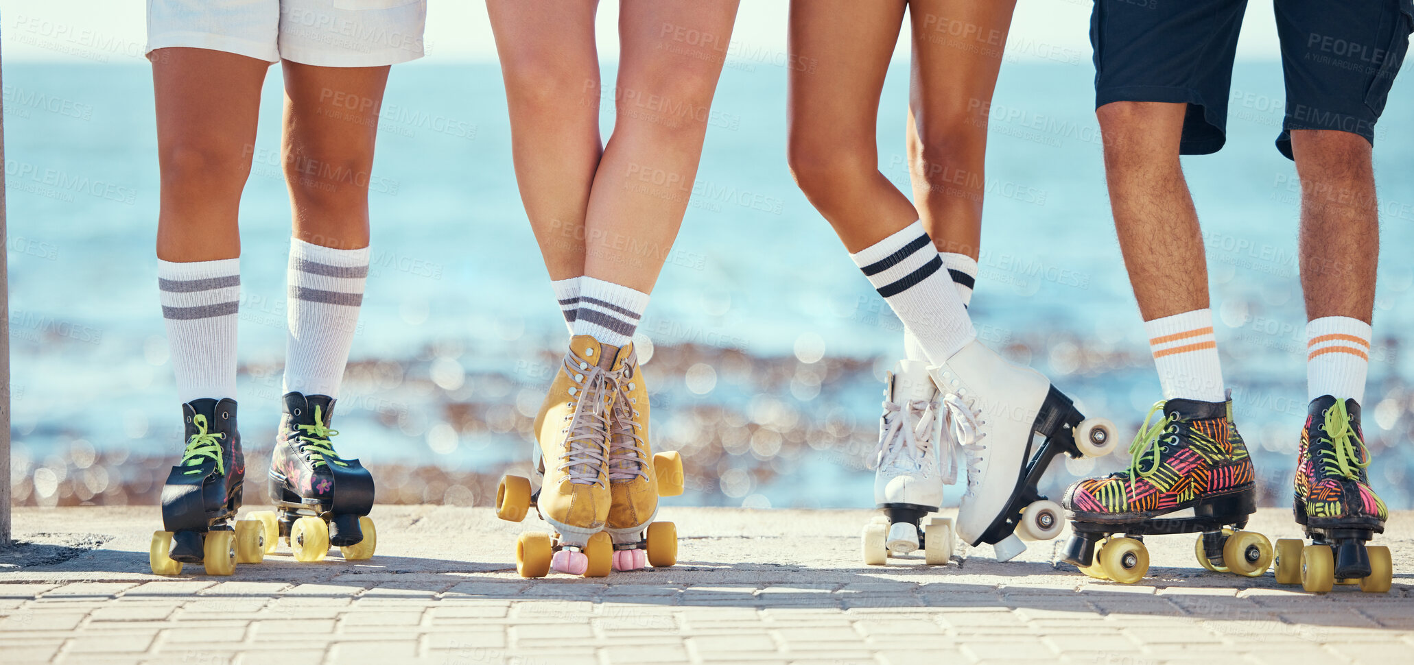 Buy stock photo Roller skates, friends and beach with a group of people on the promenade at the beach with the sea in the background. Summer, fun and lifestyle with a skaters skating outside during a sunny day