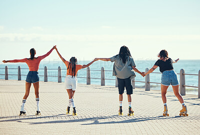 Buy stock photo Roller skaters, friends and holding hands at a beach for exercise, fitness and freedom in summer together. Group, male and young girls skating on sidewalk at sea to relax on outdoor holiday vacation