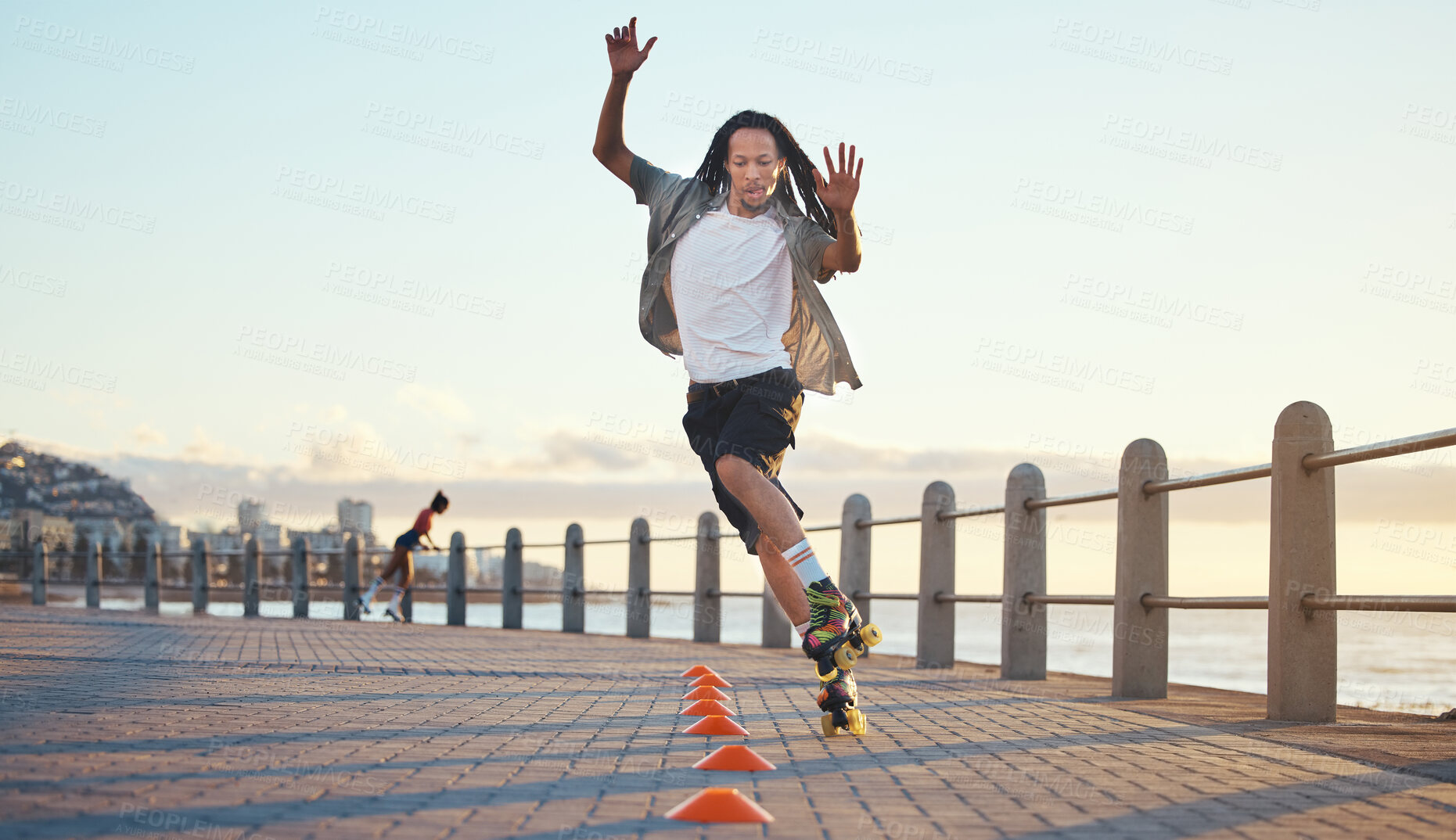 Buy stock photo Roller skating, man and fun sports by ocean, sea or beach in Florida in freedom exercise, workout drill and training at sunset. Fashion or cool local in wellness fitness skill in city park or street