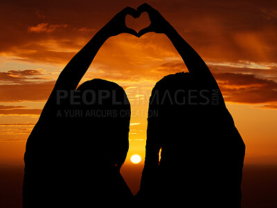 Buy stock photo Love, freedom and heart sign by couple silhouette of lesbian and lgbt pride, hand shape at sunset. Women celebrate relationship, free, in love and proud. Females celebrating their bond and status  