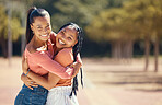 Portrait of happy friends hugging and smile outside in the park. Happy african american females embracing each other, spending the day together in the forest, enjoying a fun time during summer