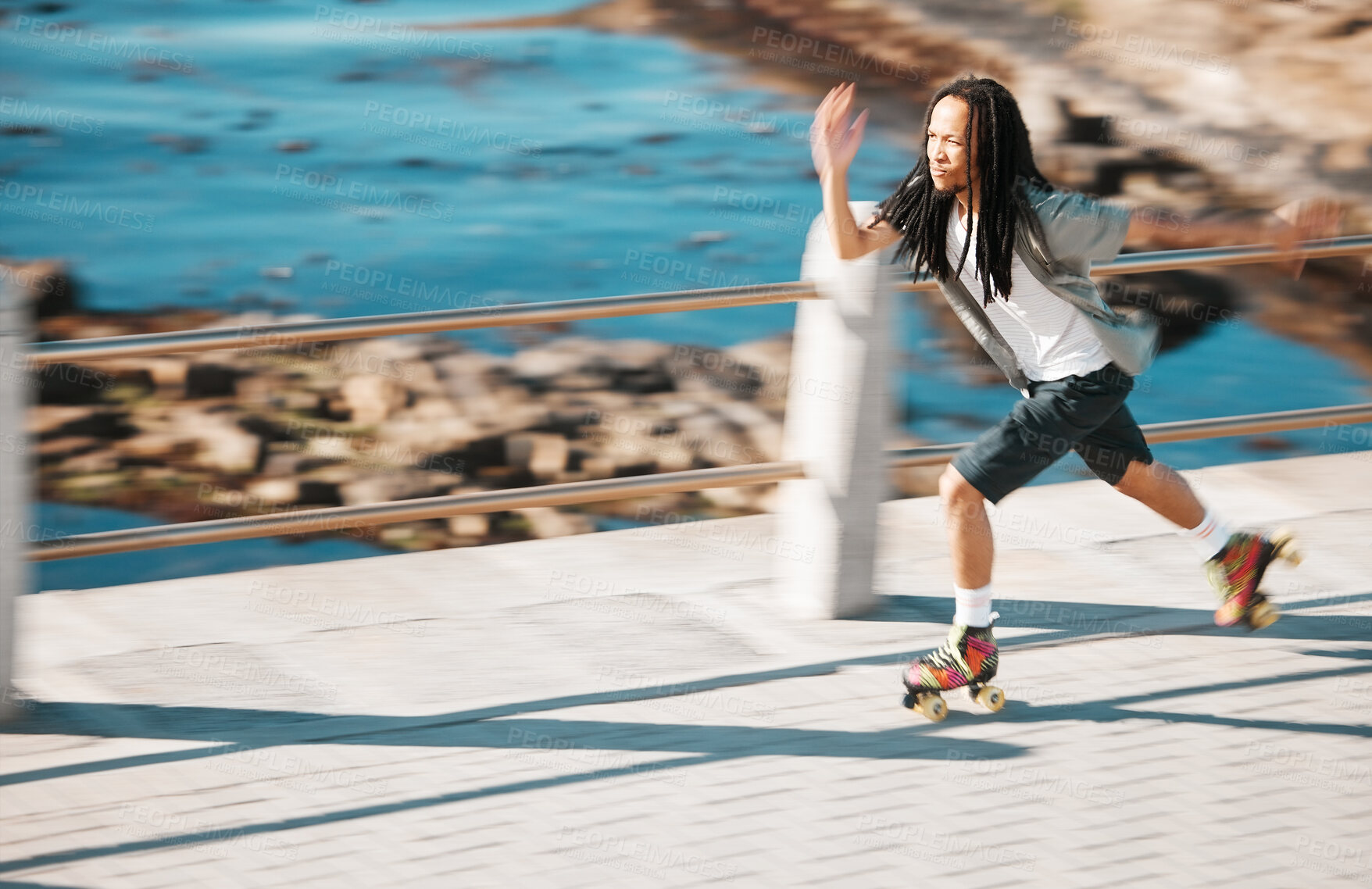 Buy stock photo Freedom, energy and roller skating with black man training and exercise along a beach outdoors. Active African American enjoying intense speed practice of fitness hobby, cardio and balance workout