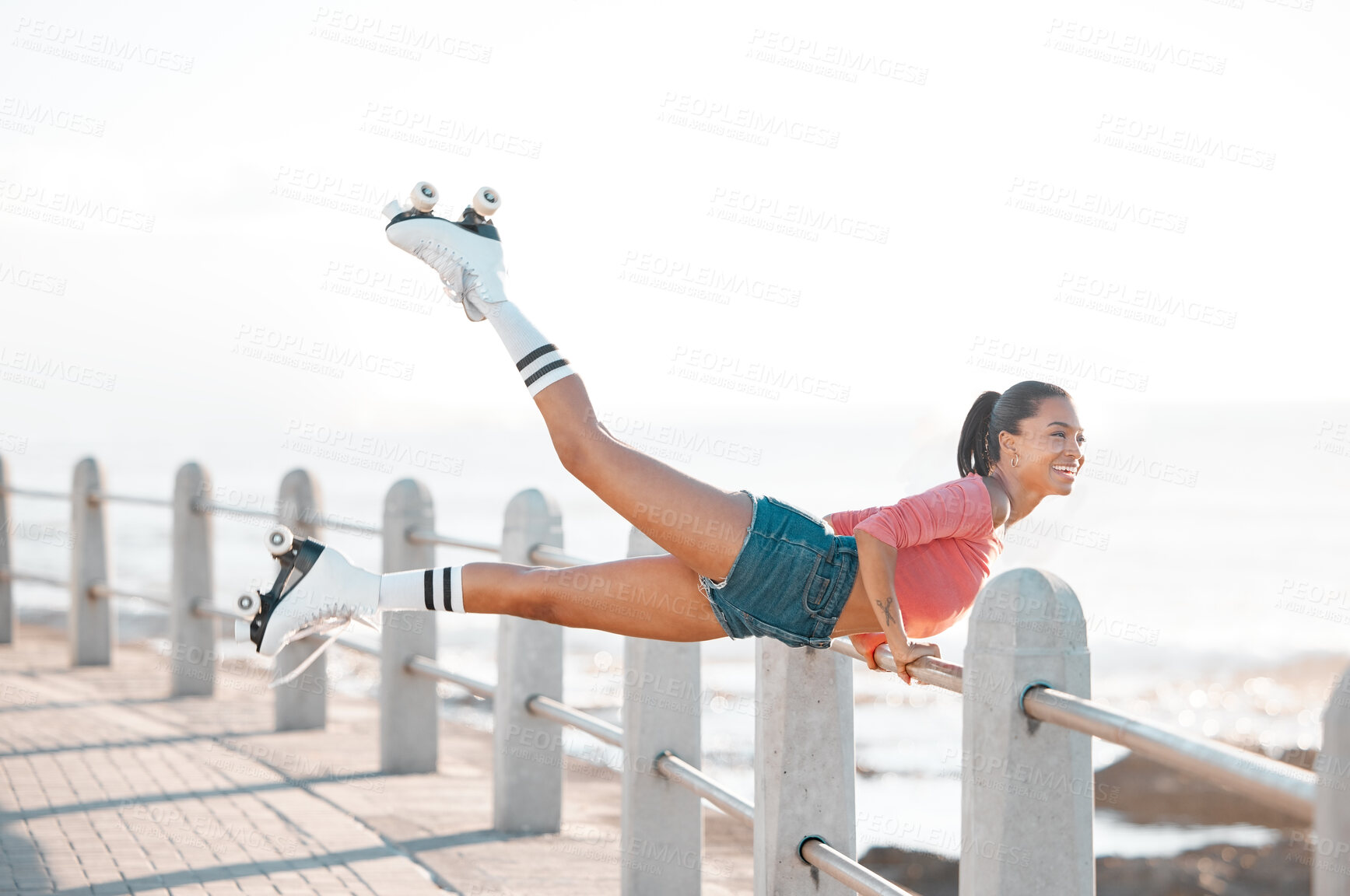 Buy stock photo Roller skate, sport and fitness workout woman from Guatemala doing training exercise by the sea. Strong Indian female skater happy about sports and healthy energy with a smile lift legs at a beach