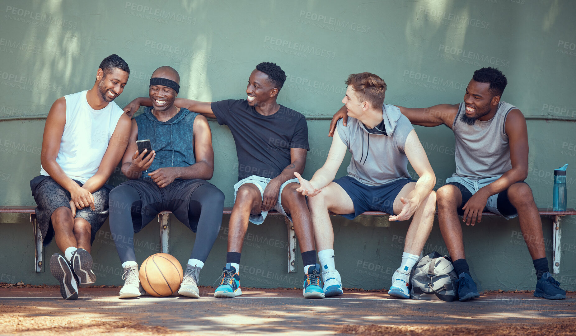 Buy stock photo Basketball, sport and friends with a team of men sitting on a bench after training, practice or a game. Teamwork, phone and exercise with a group of basket ball players outside on a sports court