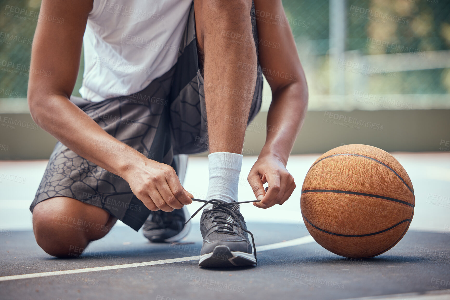 Buy stock photo Shoes, basketball and sports with a man basket ball player tying his laces on a court before a game or match. Workout, fitness and exercise with a male athlete outside for health, wellness and cardio