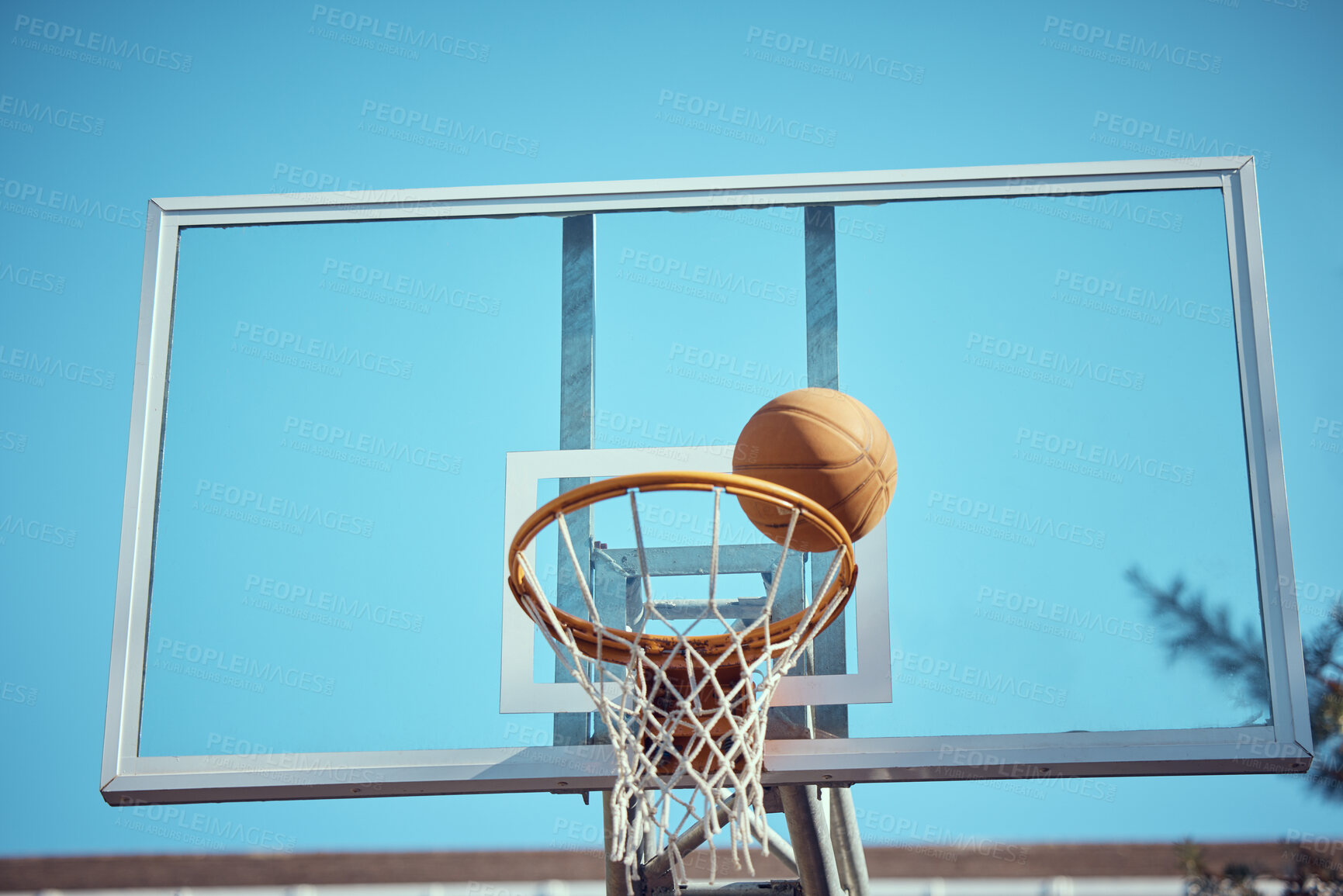 Buy stock photo Basketball court, sport and hoop or ring net against a blue sky outside. Exercise, competitive and fun hobby for athletes with a ball on the basket for a goal with copy space or mock up outdoors