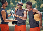 Award, success and basketball athletes with a trophy as a reward or prize after winning a competitive sports game. Challenge, fitness and happy African winners in celebration after mens championship