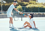 Tennis sports partner help woman get up from floor during health, fitness and exercise game on tennis court. Man and woman diversity sport partnership, teamwork or support during competition training