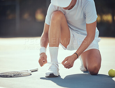 Buy stock photo Exercise, tennis and a man tying his shoes on a court before a match. Summer fitness, sport training and healthy lifestyle with tennis ball and sneakers. Motivation, workout and a knot in a shoe lace