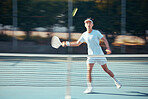 Asian tennis professional training with a racket and playing a game on court. Fit ethnic athlete running during a match. Play competitive sports workout for fitness and health alone in a sports club