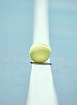 Tennis ball on the floor of a sports court during practice for a match in summer outdoors. Closeup of equipment for athlete team to train their strategy and skill for exercise and a game at stadium.