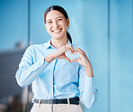 Heart, love and health with the hands of a business woman making a gesture with a smile outside in the city. Portrait of a corporate female employee showing affection and standing alone outdoors