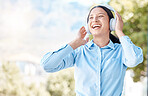 Woman with headphones happy listening to music on mp3 audio streaming song app singing to popular singer artist. Girl or young person smile, happiness and dancing to good internet joy and fun radio