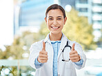 Thumbs up, smile and happy doctor, woman or physician  on a blurred city background. Portrait, like gesture or approval hands, okay or success, welcome or motivation, thumb signal or thank you sign.
