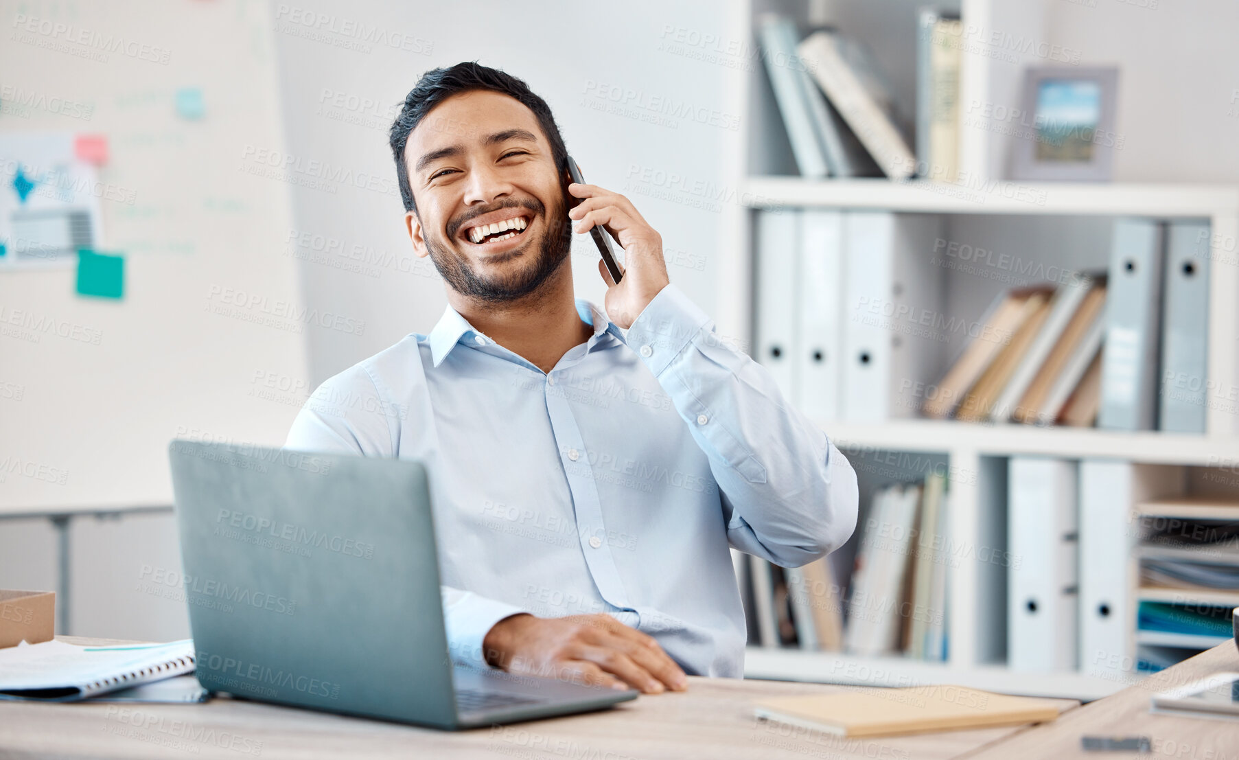 Buy stock photo Happy businessman on a phone call while working on a laptop at the desk in his modern office. Corporate, professional and company manager laughing while having a mobile conversation with technology.