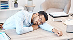 Burnout, sleeping and tired with an overworked business man asleep at his desk in the office. Exhausted, fatigue and dreaming with a young male employee napping on a table at work after working late