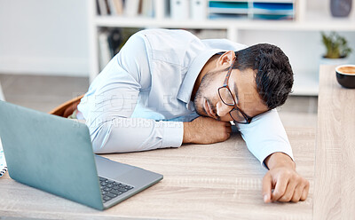 Buy stock photo Tired, headache and sleeping worker behind laptop while lying his head on his desk in his office. Stress, burnout and chronic fatigue with young professional male feeling exhausted and overworked