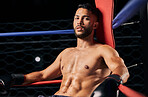 Boxing, sport and workout with a male boxer in the ring for a fight, match or training. Health, fitness and exercise with a strong sports man resting between rounds of a fighting competition 