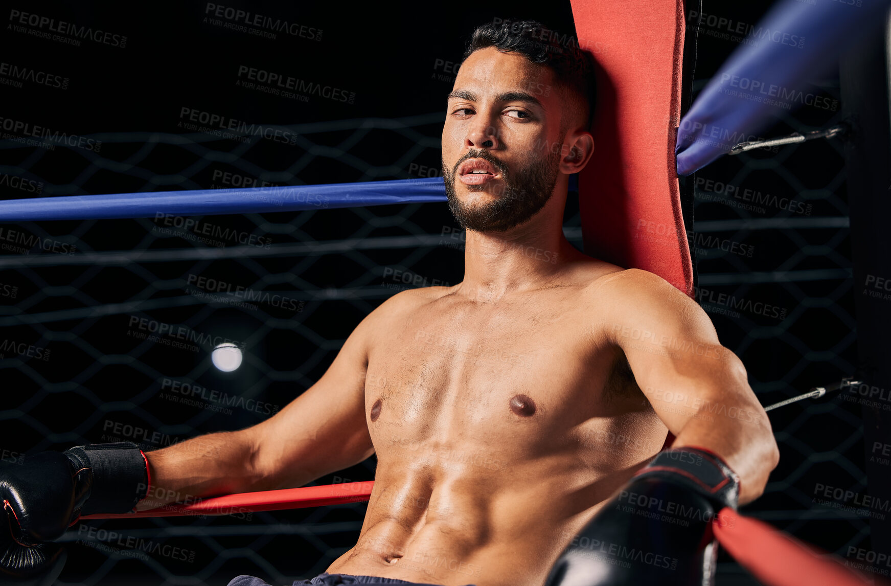 Buy stock photo Boxing, sport and workout with a male boxer in the ring for a fight, match or training. Health, fitness and exercise with a strong sports man resting between rounds of a fighting competition 