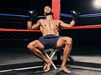 Tired boxer in boxing ring or an arena, dark background and spotlight for wrestling, mma fighting competition or sports match. Strong man with boxing gloves for workout, exercise or fitness training