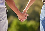 Hand, love and couple with a man and woman holding hands outside in care, trust and relationship. Closeup of a male and female walking outside together for romance and affection with trust outdoors