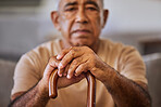 Portrait of sad senior man with a cane for walking support, assistance and help. Depression, mental health and hands of elderly man with walking stick depressed over retirement lifestyle or pension