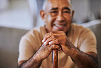close up portrait of a happy, kind black senior mans hands with wrinkles, holding a walking stick and smiling outside a retirement home sitting on the hallway relaxing and waiting on the queue