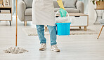 Legs of home cleaning woman with house equipment, mop and bucket for floor hygiene, dust and dirt. Girl, cleaner or worker doing interior house cleaning service with living room cleanliness detergent