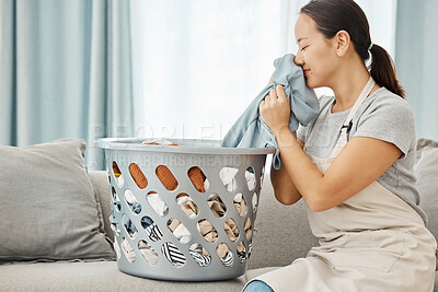 Buy stock photo Woman on sofa smell clean laundry at home, in living room while cleaning or doing housekeeping. Lady smile on couch with washing basket in lounge, sniff fresh fabric or clothes in house.