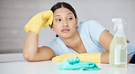 Thinking, cleaner and woman at table in home tired of spring cleaning the kitchen interior. Housekeeper girl with domestic gloves and detergent unhappy, frustrated and moody with tidy job.