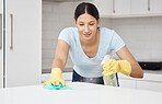 Cleaning service, table and maid in the kitchen working with spray bottle to scrub messy dirt with a cloth soap detergent. Happy, woman and employee doing housekeeping job with gloves with products