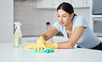 Cleaner woman cleaning kitchen counter with cloth, spray bottle and rubber gloves in modern home interior. Service worker working with soap liquid, hygiene equipment or wipe surface for spring clean