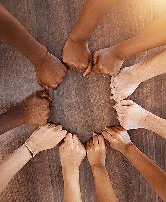Buy stock photo Hands, collaboration and motivation with the fists of a team in a circle or huddle on a wooden background from above. Teamwork, goal and target with a group of people ready for success in unity
