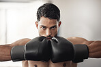 Fitness, health and a man with gloves for boxing at a gym. Exercise, workout and training for boxer building muscle strength and power for mma. Motivation, sports and healthy competition for fighter.