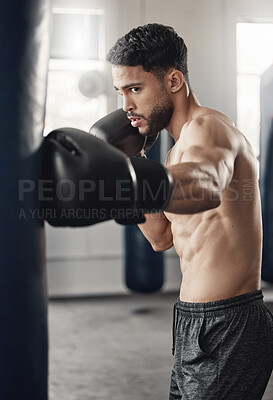 Buy stock photo Punching bag, boxing and boxer man in workout training or exercise in a gym. Strong, powerful and serious athlete or personal trainer with fitness gear for muscle strength, wellness or health goals