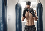 Boxer, cardio and man training with boxing gloves for sport, workout and exercise in gym. Athlete with motivation, strength and muscle practicing for match with fitness, health and wellness lifestyle