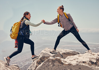 Buy stock photo Happy women help while hiking up a rocky mountain in nature with backpack. Females friends exercise in nature park climbing and jumping while with sportswear training or trekking together outdoors