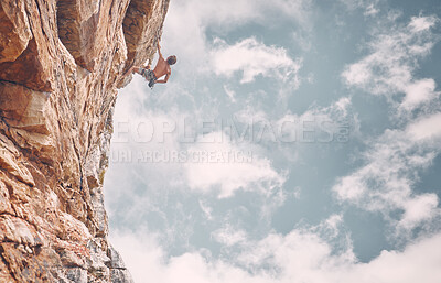 Buy stock photo Rock climbing, sports and adventure with man on mountain against a blue sky background for fitness, challenge and training. Motivation, freedom and strong male athlete on cliff for adrenaline