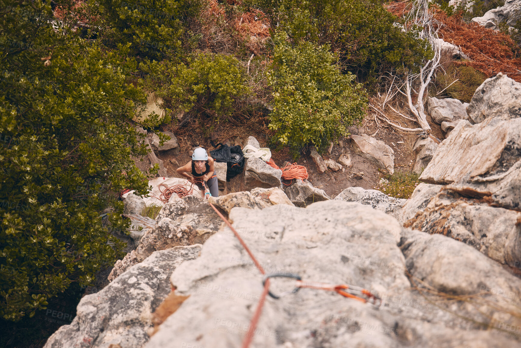 Buy stock photo Climbing, abseiling and adventure with a woman climber hiking on a mountain outside in nature, the woods or the forest. Sports, health and fitness with a female holding a rope and scaling a rock