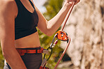 Rock, mountain and nature sport climbing of a woman in the mountains about to climb a stone wall. Sports person on a summer day with carabiner, rope and harness ready to start an adventure experience