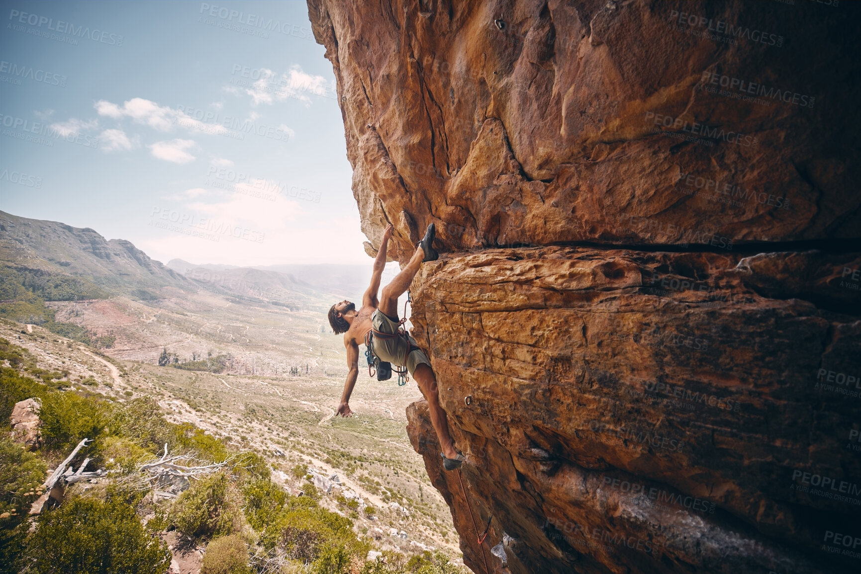 Buy stock photo Rock climbing, rope and fearless mountain climber on a cliff, big rocks and risky challenge alone in summer. Mountaineering, bouldering and strong man training his body for balance outdoors in nature