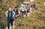 Group of friends hike trail up mountain, to camp in nature landscape on extreme adventure or holiday. Team of people explore earth together, on hiking trip to mountains or hill while on vacation.