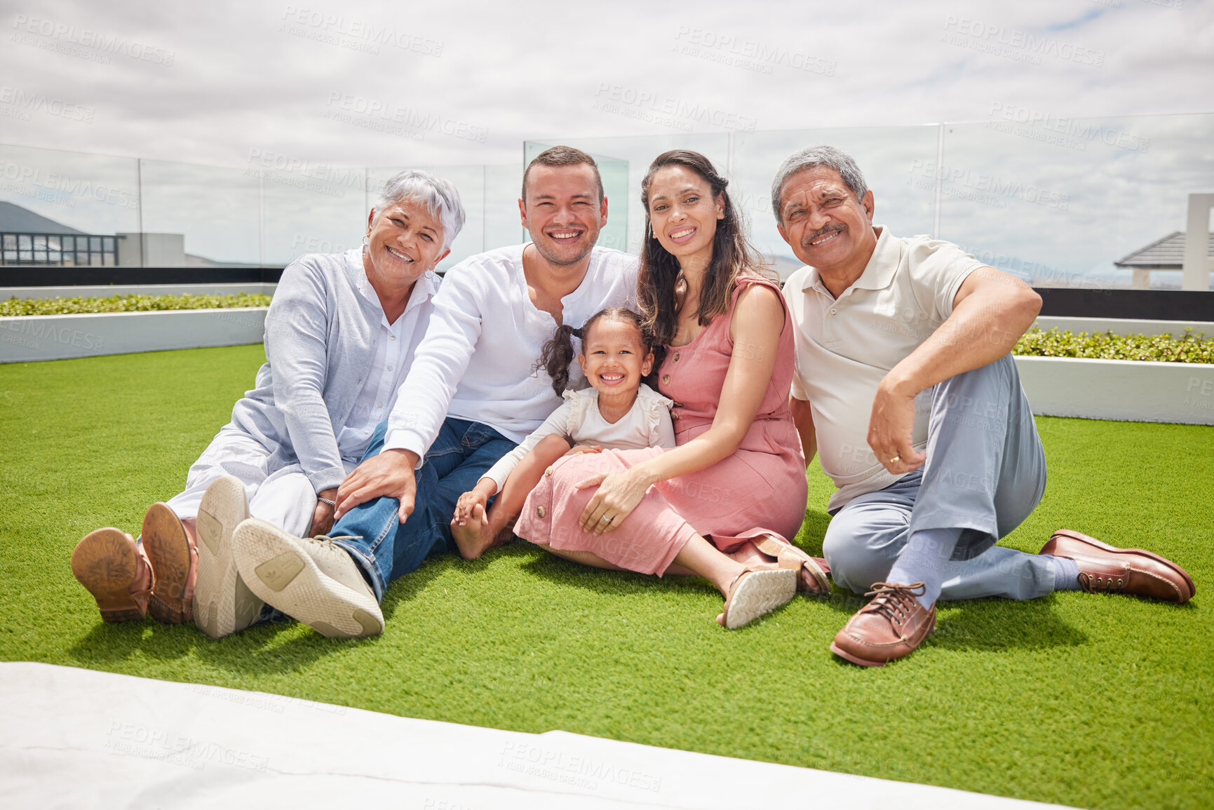 Buy stock photo Portrait of happy big family with girl, love and a smile while sitting on backyard, lawn or grass. Grandfather, grandmother and mom with dad and child or kid bonding outside home in the sunshine.

