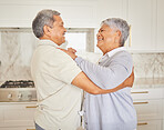 Love, happy and elderly couple dance in a kitchen at home, bonding and having fun. Mature man and woman hug, being playful and loving, enjoying their relationship and retirement together indoors