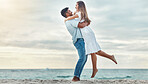 Happy couple at beach lift and hug to celebrate love on romantic sunset tropical ocean water Bali luxury vacation travel or holiday. Woman and man dating and celebration for engagement announcement