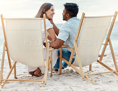 Buy stock photo Couple, love and beach vacation of summer holiday with interracial lovers sharing a romantic moment while sitting on chairs in the sand. Happy and young man and woman on tropical honeymoon together