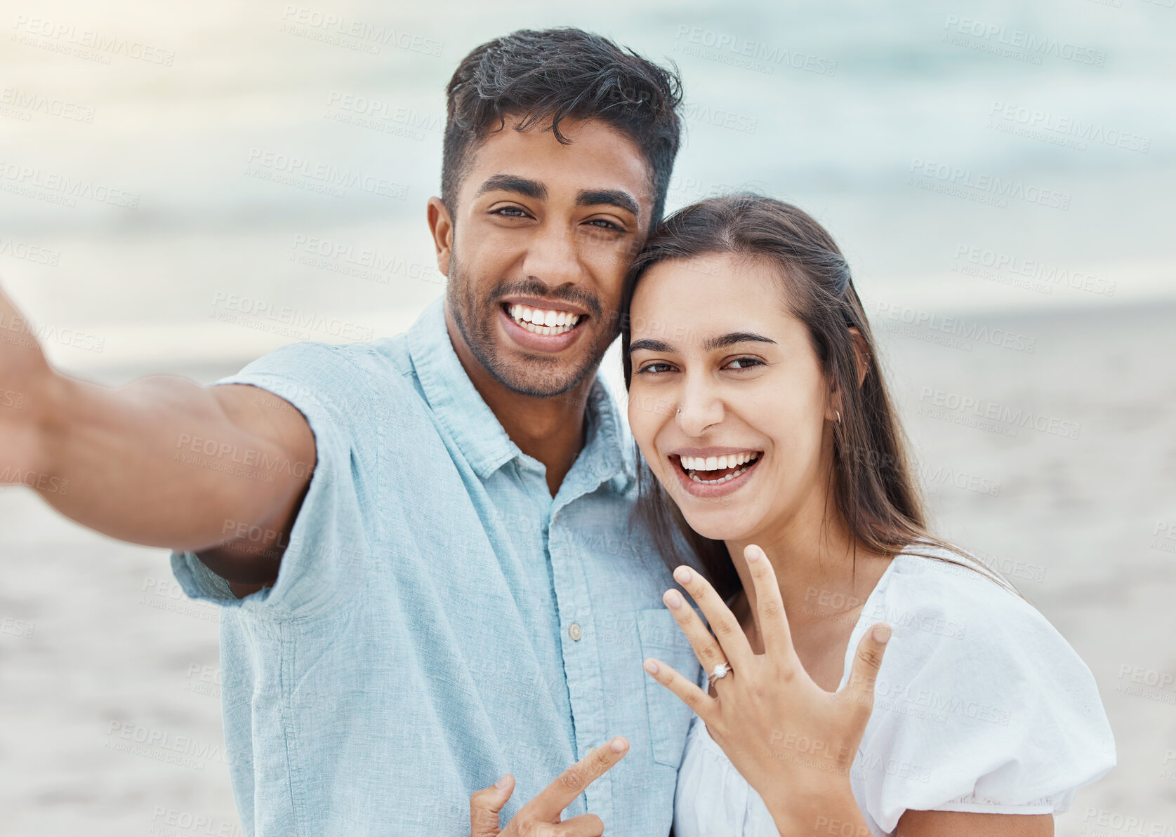 Buy stock photo Couple selfie, engagement proposal or wedding ring at the beach, jewelry or engaged announcement. Romance face portrait, love and commitment of man and woman by the ocean celebrating with a smile.


