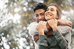 Happy couple hugging in nature at a park while on a date during a spring vacation with bokeh. Love, care and romantic young man and woman embracing each other in a outdoor garden while on holiday.
