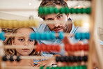 Education, learning and abacus in family homeschooling of a father teaching daughter maths in order to count at home. Dad helping little girl in mathematics and arithmetics on a calculating tool