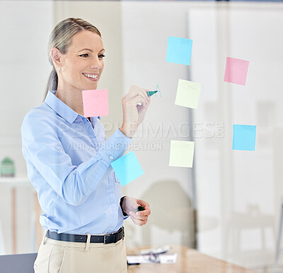 Buy stock photo Writing, planning and thinking with sticky notes on a glass in a modern office. Happy woman manager, leader or ceo plan strategy on post it paper in a corporate marketing and advertising company
